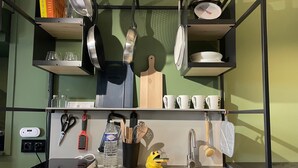 Une cuisine équipée d’un évier, d’une machine à café, d’une balance et de divers ustensiles.