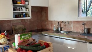 A kitchen with white cabinets, a wooden fruit crate, and a hanging light fixture.