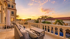 Una terrazza panoramica sul tetto con posti a sedere all'aperto, una piscina e vista sul tramonto.