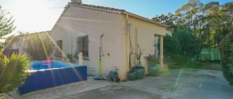 A single-story building with a flat roof, a small attached garage, and a paved driveway.