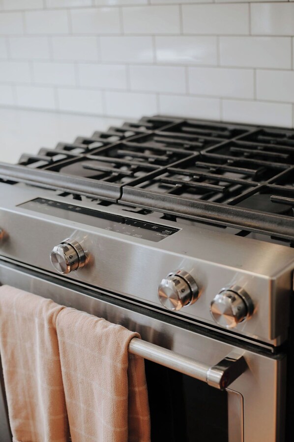Une cuisinière en acier inoxydable dotée de quatre brûleurs et d’un panneau de commande.