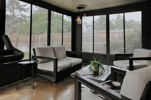 Un salon moderne avec un canapé, des fauteuils, une table basse et une plante en pot.