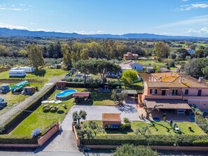Une vue aérienne d’un quartier résidentiel avec des maisons, une piscine et une grande tente.