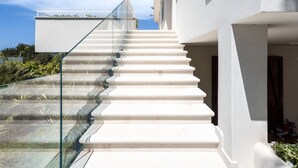 A modern staircase with glass railings leading to a white building. - Cosy apartment for 4 guests with A/C, WIFI, TV and terrace (Terrasini)