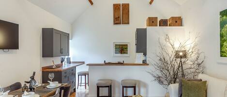 A modern living space with a dining area, kitchen, and seating area.