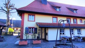 A building with a red-tiled roof, multiple windows, and outdoor seating. - Gasthaus zum Raben (Horben)