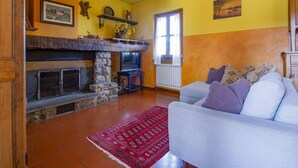 Una sala acogedora con chimenea, un sofá y una alfombra roja.