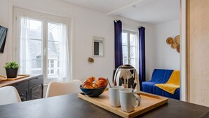 A modern kitchen with a dining table, a coffee pot, and a tray with croissants and mugs. - Beautiful apartment for 2 guests with WIFI, TV and pets allowed (Louvières)