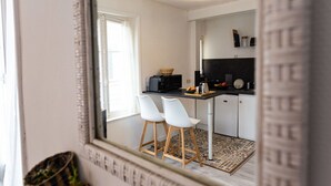 A modern kitchen with white cabinets, a black countertop, and a wooden stool. - Beautiful apartment for 2 guests with WIFI, TV and pets allowed (Louvières)