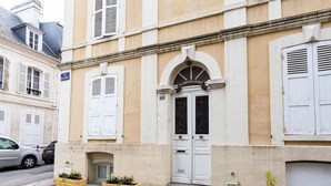 A building with a white door and a sign above it that reads "LA BATELIERE". There are three flower pots on the ground in front of the door. - Beautiful apartment for 2 guests with WIFI, TV and pets allowed (Louvières)