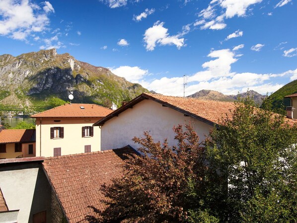 A building with a tiled roof, surrounded by trees and mountains.