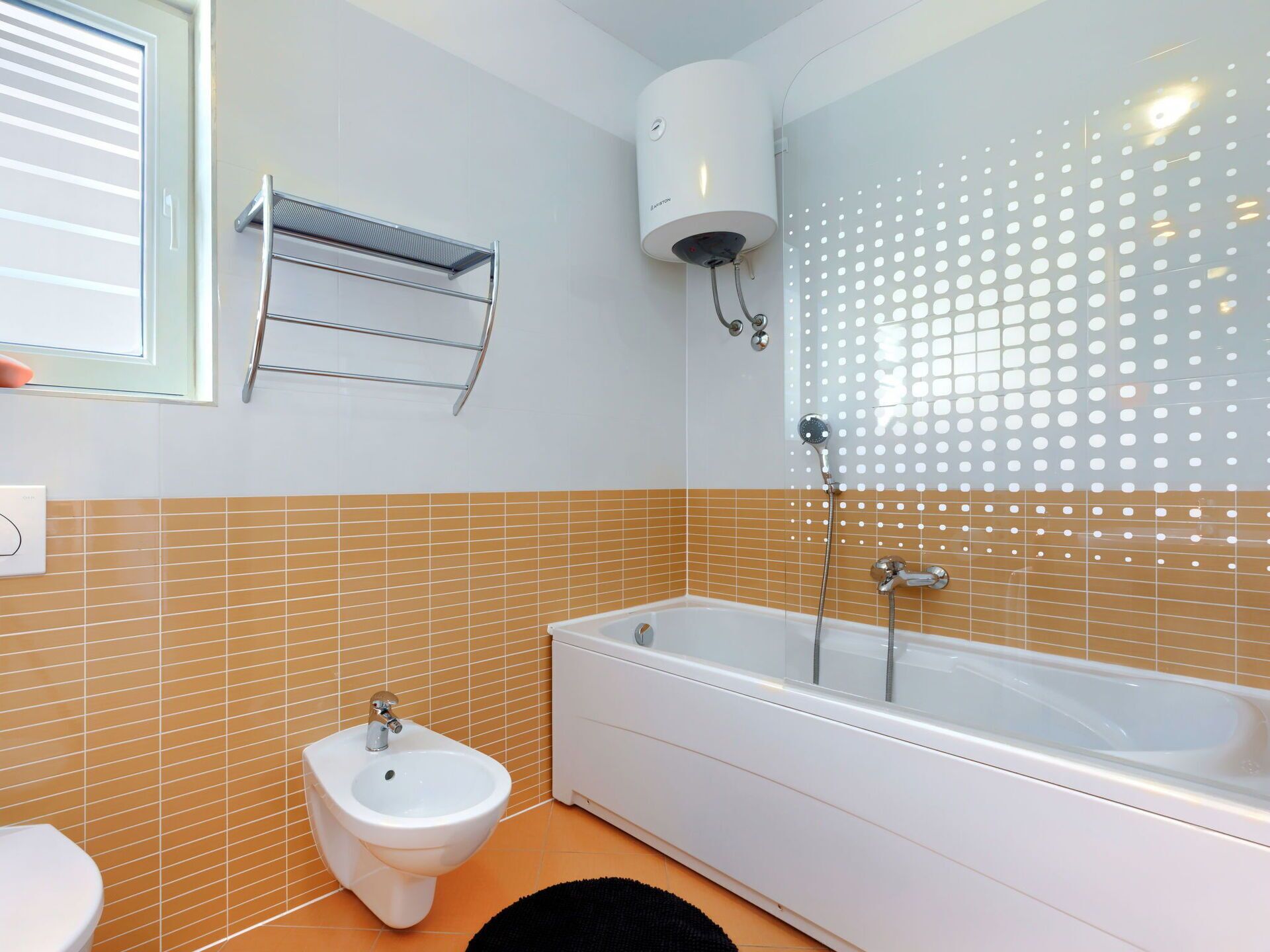 A bathroom with a bathtub, a bidet, a towel rack, and a shower enclosure.