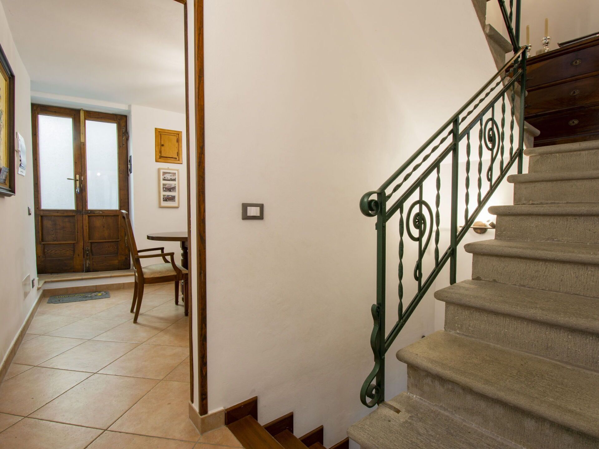 Un escalier avec une rampe métallique menant à un palier.