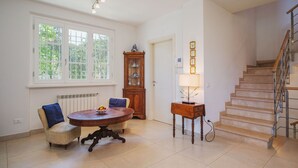 A spacious room with a dining table, chairs, a cabinet, and a staircase. - Beautiful private villa for 5 guests with TV and patio (Camaiore)