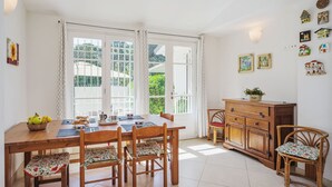 A dining area with a wooden table, chairs, and a cabinet. - Beautiful private villa for 5 guests with TV and patio (Camaiore)