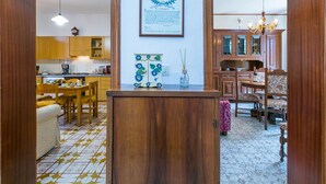 Una cocina amplia con armarios de madera, un comedor con mesa y sillas, y una sala de estar con piso estampado.