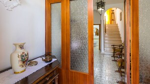 Puerta de madera con paneles de vidrio satinado que da a una escalera.