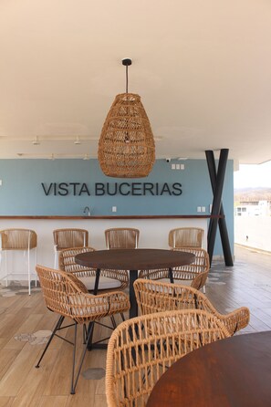 Enjoy meals in this stylish dining area with a round table and six chairs, surrounded by a pendant light and a unique sign.