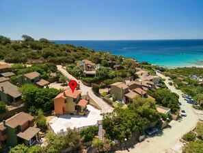 A coastal residential area with houses, a clear view of the sea, and a marked location. - Lovely apartment for 6 people with A/C, TV, patio and panoramic view (Quartu Sant'elena)