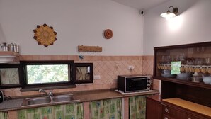 Eine Küche mit Spüle, Mikrowelle und einem Schrank mit Gläsern.