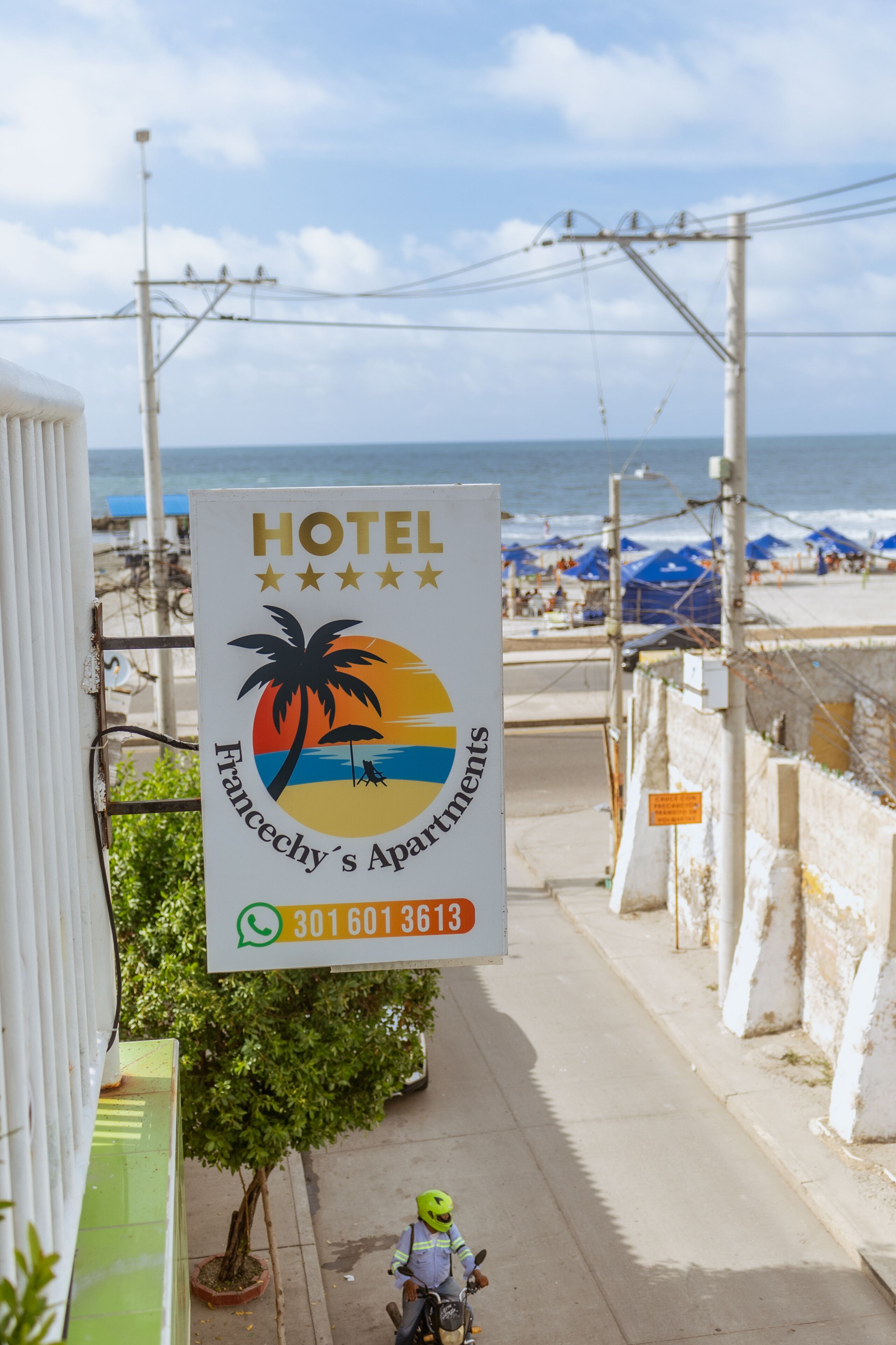 Ein Hotelschild mit Blick auf den Strand, einer Palme und einem Sonnenuntergang.