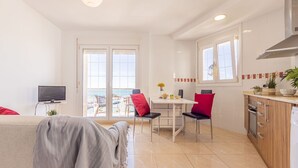 A modern apartment with a balcony, a dining area, and a kitchen.