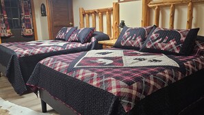 Ein Zimmer mit zwei Betten, einem Holzkopfteil, einer Deckenleuchte und einer Wanddekoration.