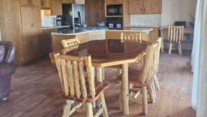 Eine rustikale Küche mit Holzschränken, einer zentralen Kochinsel und einem Essbereich mit Holzkästen.