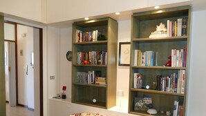 Una camera da letto con un letto, due librerie, un comodino e una abat-jour.