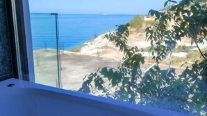 A bathtub with a view of the sea and a plant in the background. - Nili Deluxe (Sarandë)