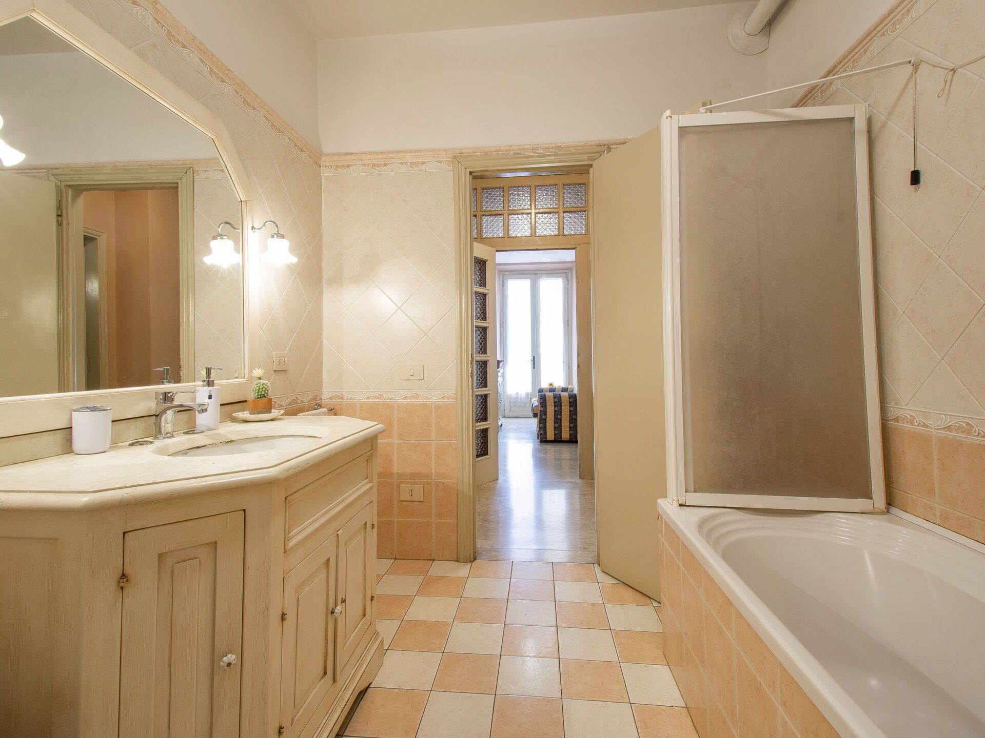 A bathroom with a large mirror, two sinks, a bathtub, and a shower.
