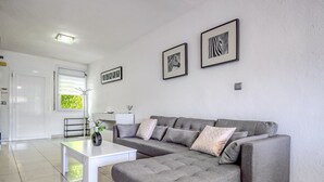 Una sala de estar moderna con un sofá seccional gris, una mesa de centro blanca y dos cuadros con imágenes de cebra en la pared.