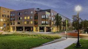 A multi-story building with a modern architectural design, featuring a mix of brick and glass facades.
