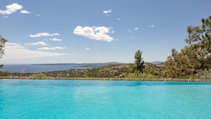 A clear blue pool with a view of a coastal landscape and distant hills. - Nice apartment for 2 guests with pool, WIFI, TV and balcony (Roquebrune-sur-argens)