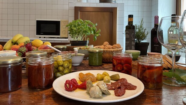 A kitchen counter with various food items, jars, and a plate of food.