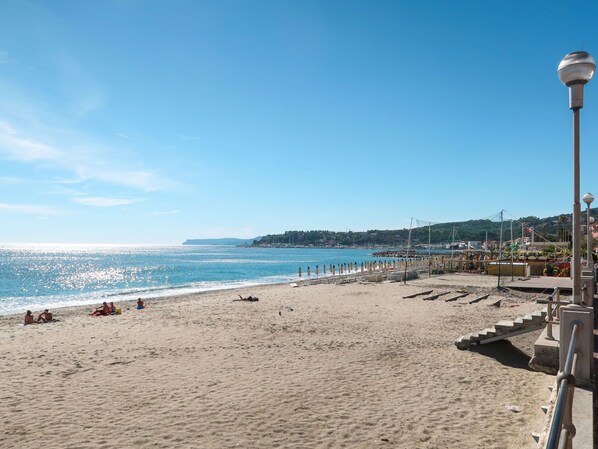 A beach with a clear sky, a sandy shore, and a distant view of hills. - Cosy apartment for 6 people with A/C, hot tub, WIFI, TV, terrace and pets allowed (Varazze)