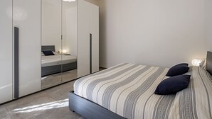 A modern bedroom with a large bed, a mirror cabinet, and a unique ceiling light fixture. - Nice apartment for 6 guests with WIFI, A/C, hot tub, TV, terrace and pets allowed (Varazze)