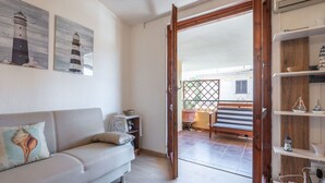 Un salon comprenant un canapé, un banc en bois et une étagère ornée d’objets décoratifs.