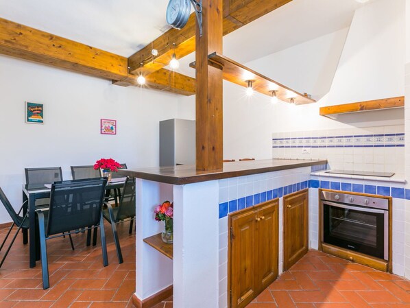 Una cocina con techo de madera, salpicadero de azulejos y horno empotrado.