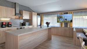 A modern kitchen with wooden cabinets, a central island, a microwave, and a coffee maker. - Beautiful private villa for 22 guests with WIFI, TV, patio and pets allowed (Fügen)