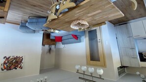 Eine moderne Küche mit Holzbalkendecke, einer eingebauten Schranke und einer Pendelleuchte.