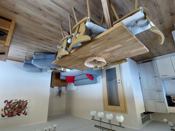Eine moderne Küche mit Holzbalkendecke, einer eingebauten Schranke und einer Pendelleuchte.