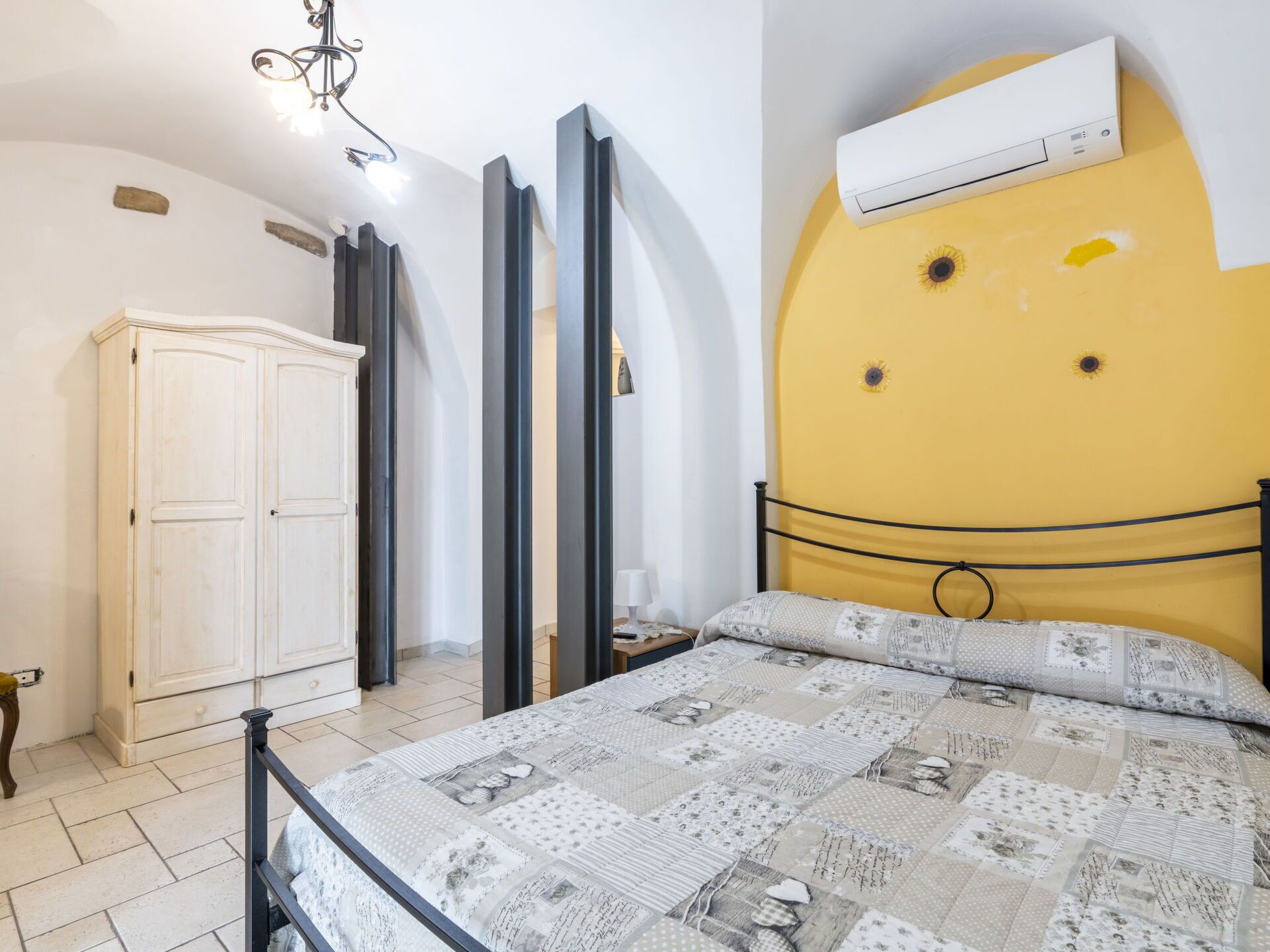 Une chambre à coucher comprenant un lit, une armoire, un miroir et un appareil de climatisation.
