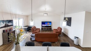 Un salon moderne comprenant un canapé, un téléviseur à écran plat et un coin repas.