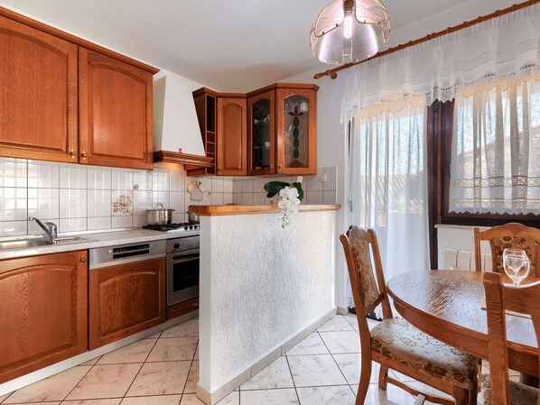 Enjoy cooking in this well-equipped kitchen with a central island, stainless steel sink, stove, and oven.