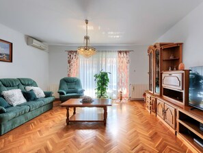 Relax in this stylish living room with a green sofa, armchair, and wooden coffee table.