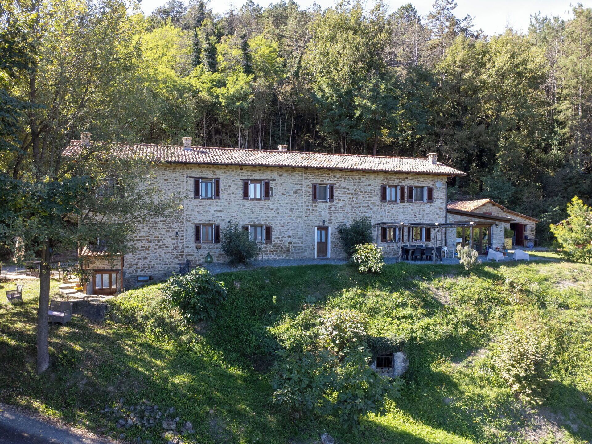 A stone building with multiple windows and a small attached structure.