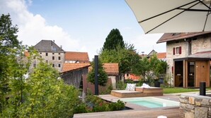 A wooden deck with a pool, a lounge chair, and a stone wall. - Beautiful private villa for 3 people with private pool, WIFI and TV (Farra D'alpago)