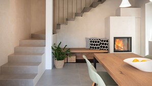 A modern kitchen with a wooden table, a built-in stove, and a staircase leading to an upper level. - Beautiful private villa for 3 people with private pool, WIFI and TV (Farra D'alpago)