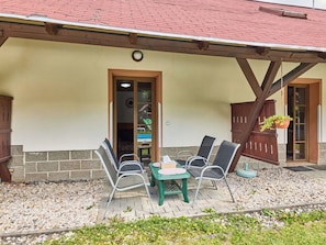 An outdoor seating area with a table and chairs, a wooden pergola, and a view of the interior through a doorway. - Lovely apartment for 4 people with WIFI, pool, TV and patio (Jablonec Nad Nisou)